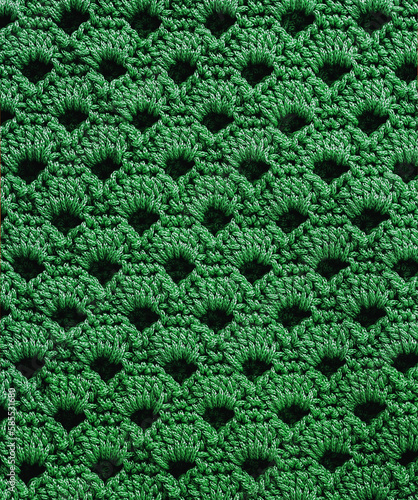 Green crochet fabric with open shell pattern. Knitted background.