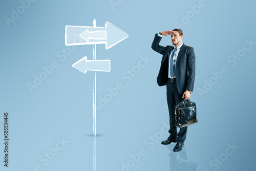 Fotografie Young european businessman thinking which path to choose on blue background with sign sketch