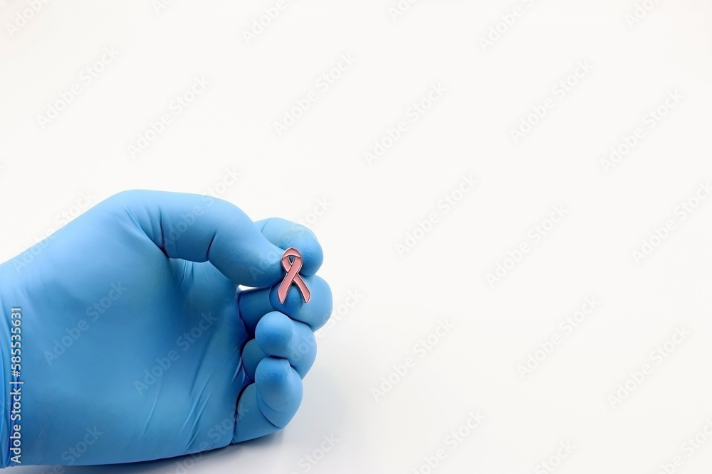 Fototapeta premium Doctor's or researcher's glove with a pink bow. Fighting cancer