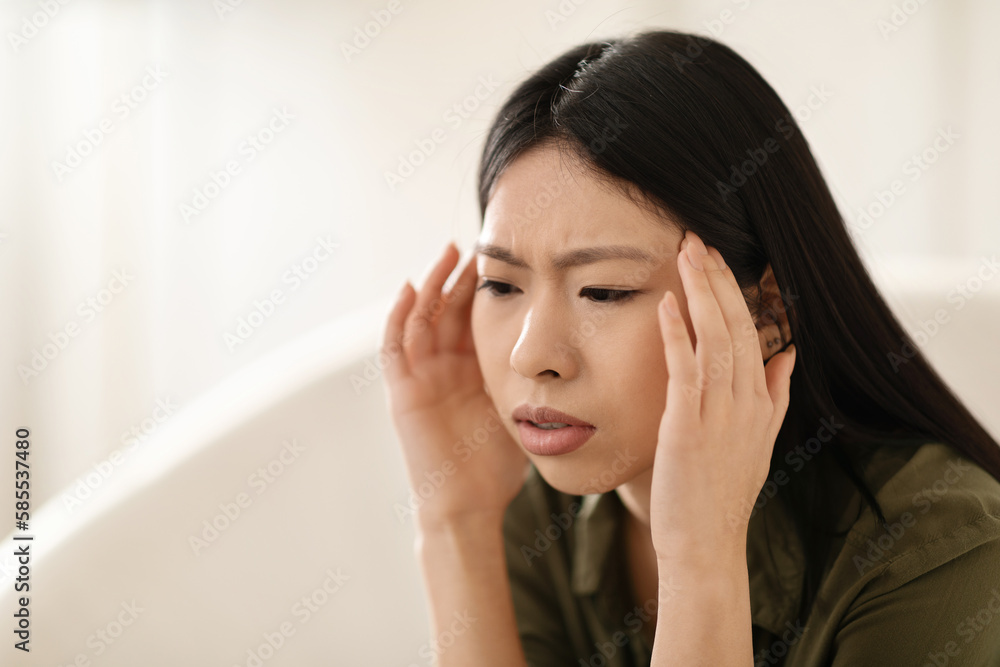 Sick asian woman touching his head, home interior Sick asian woman touching his head, home interior