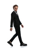 businessman walking to side and looking at camera