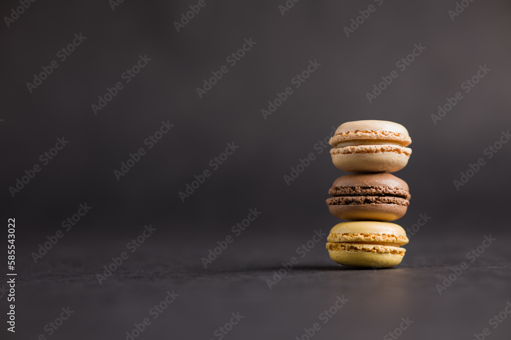 Sweet colorful macarons dessert on a black background Sweet colorful macarons dessert on a black background