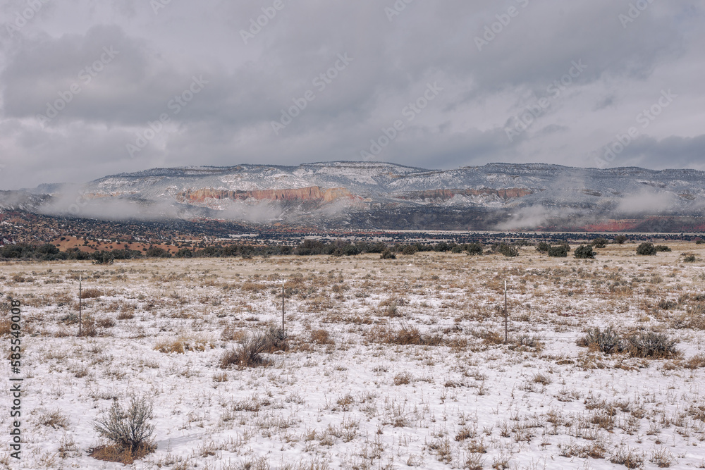 Epic scene of snow covered mountains with fog behind snow covered desert field in the high desert Epic scene of snow covered mountains with fog behind snow covered desert field in the high desert