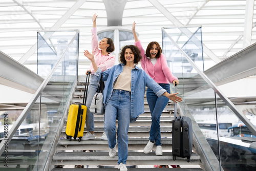 Travelling Together. Three Cheerful Women With Suitcases Having Fun At Airport