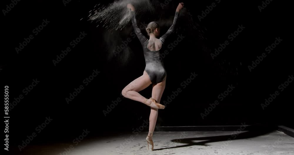 Tips on toes. Young graceful ballerina dancing and jumping in flour alone isolated on black isolated background. Art, motion, action, flexibility, inspiration. Classiacal ballerina in pointe shoes Tips on toes. Young graceful ballerina dancing and jumping in flour alone isolated on black isolated background. Art, motion, action, flexibility, inspiration. Classiacal ballerina in pointe shoes