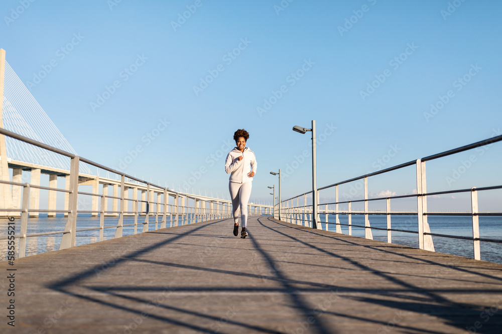 Outdoor Sports. Happy Young Black Female Running On Pier Near Sea Outdoor Sports. Happy Young Black Female Running On Pier Near Sea