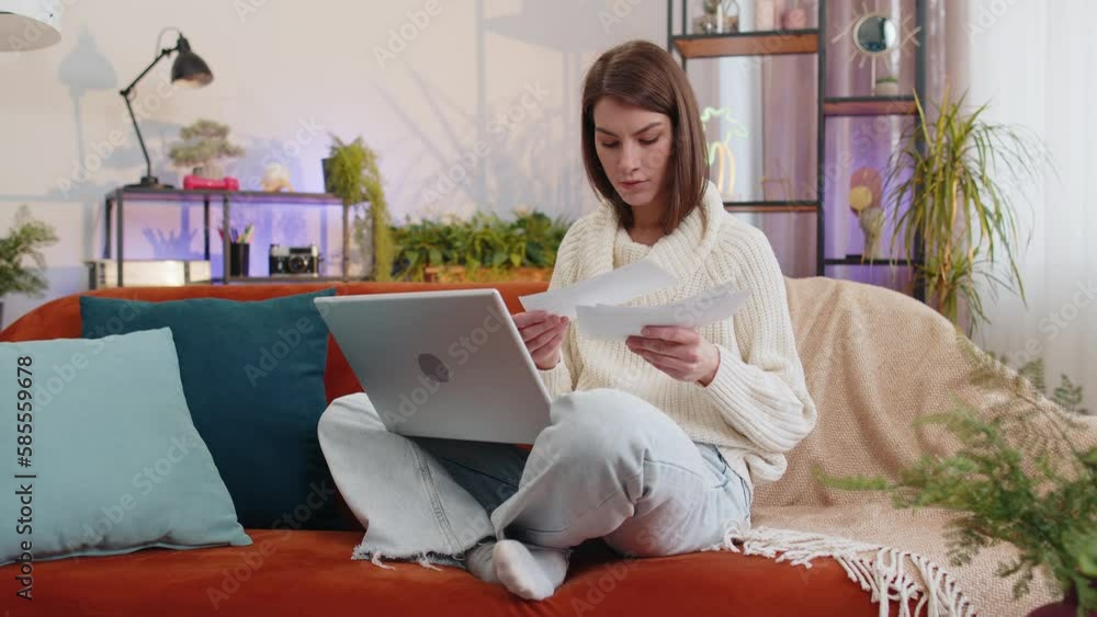 Stressed woman at home room looking at unpaid bank debt bills, doing paperwork, planning budget, calculate finances mortgage payments. Portrait of girl throws paper bills sitting on couch. Lifestyles Stressed woman at home room looking at unpaid bank debt bills, doing paperwork, planning budget, calculate finances mortgage payments. Portrait of girl throws paper bills sitting on couch. Lifestyles