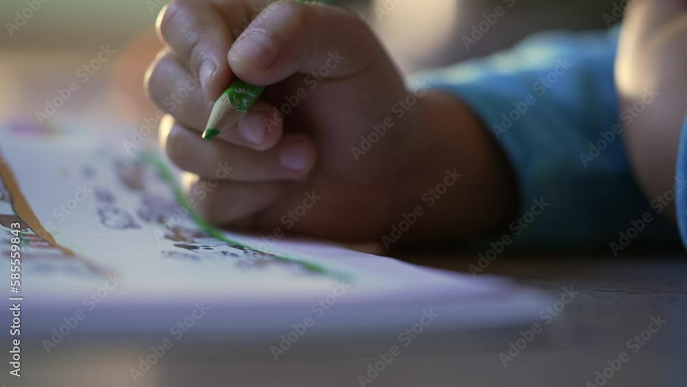 Closeup child hand drawing on paper with green color pencil. Childhood creative development Closeup child hand drawing on paper with green color pencil. Childhood creative development