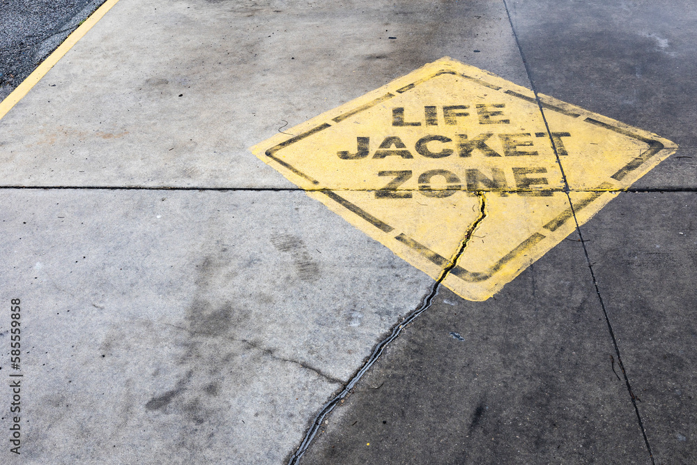 Life Jacket Zone warning sign painted on the pavement. foto de Stock