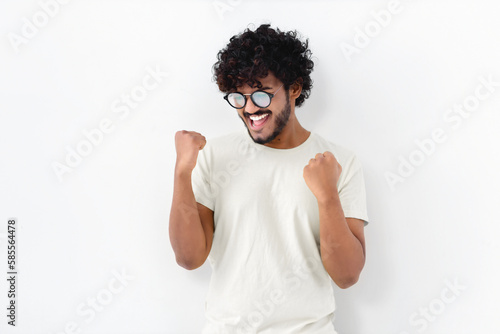 Принти на полотні Happy ecstatic cheerful Asian man with curly hair in white t-shirt and glasses s