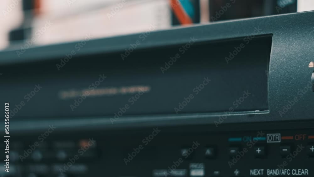 Eject VHS tape cassette from VCR player. Male hand pushes a button and