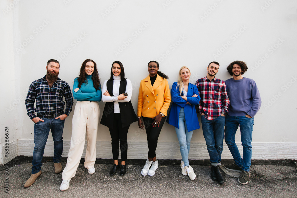 Obraz premium Mixed race group of stylish people standing in a row against a wall looking at camera. Copy space.