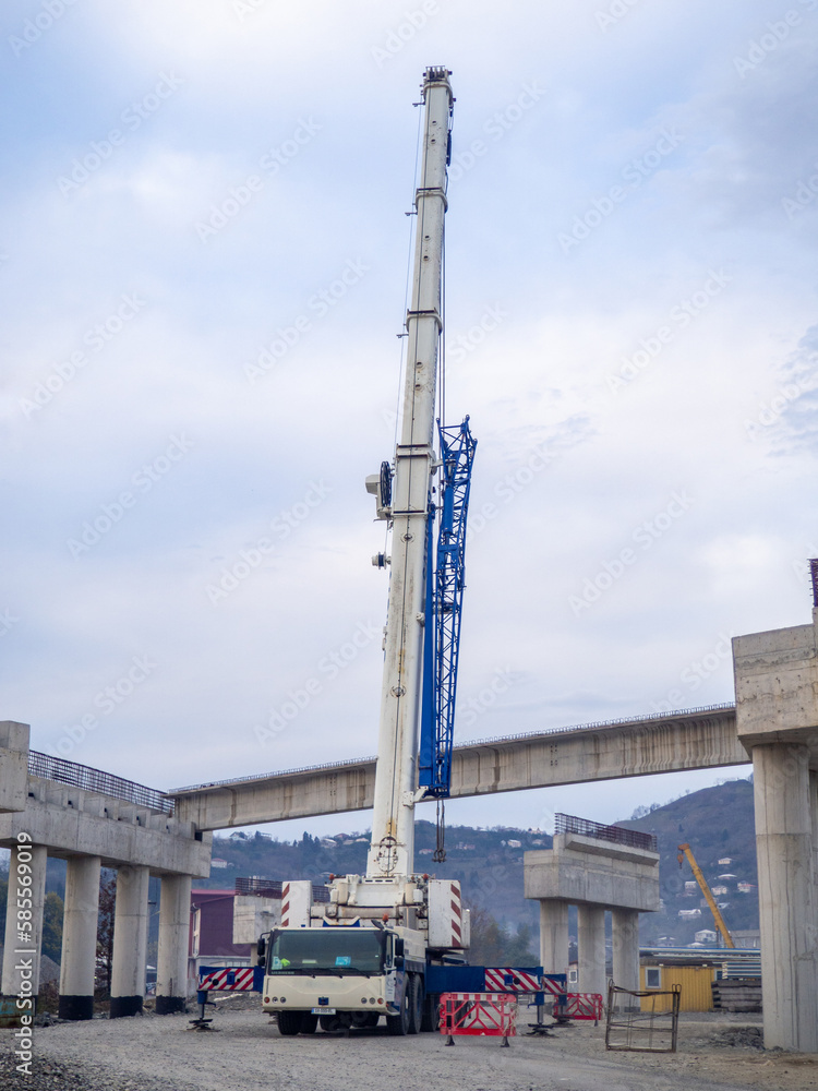 Bridge construction. Bridge supports in the mountains. Interchange construction. Truck crane.