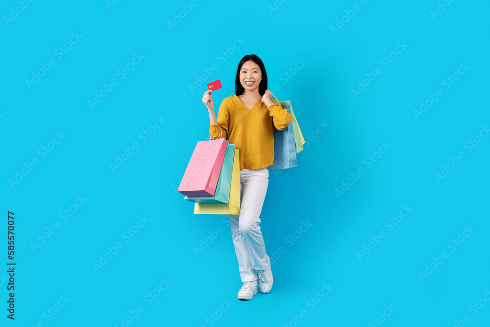 Pretty chinese woman enjoying easy shopping with bank card Pretty chinese woman enjoying easy shopping with bank card