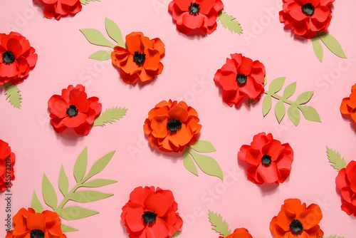 Paper poppy flowers with leaves on pink background
