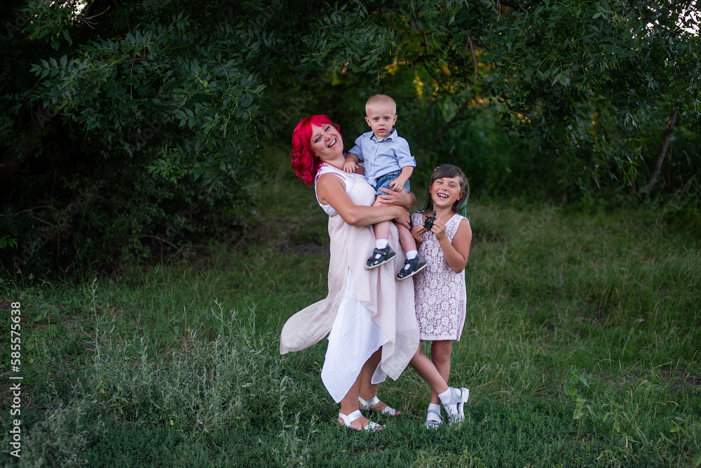 Obraz premium Diversity family portrait, mother with two children in lush, botanical green natural background.