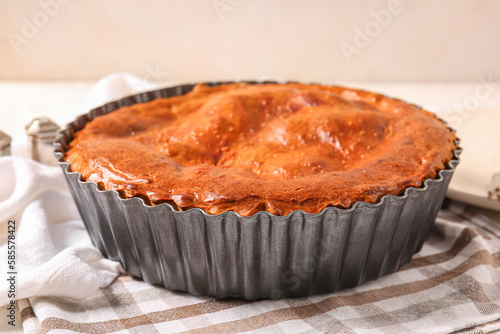 Delicious meat pie in baking form on white grunge table