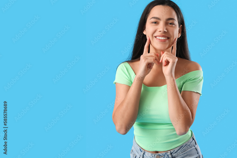 Beautiful young woman smiling on blue background Beautiful young woman smiling on blue background