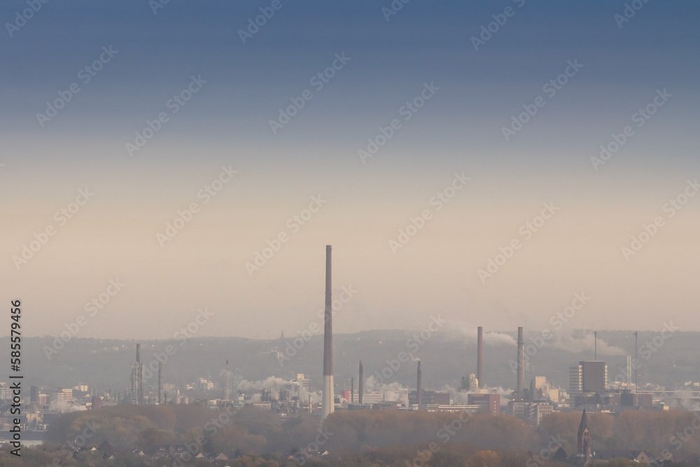 Selective blur on a industry complex, a factory with high chimneys and smokes and fumes in Leverkusen, near Cologne, Germany, polluting the atmosphere and the local environment.