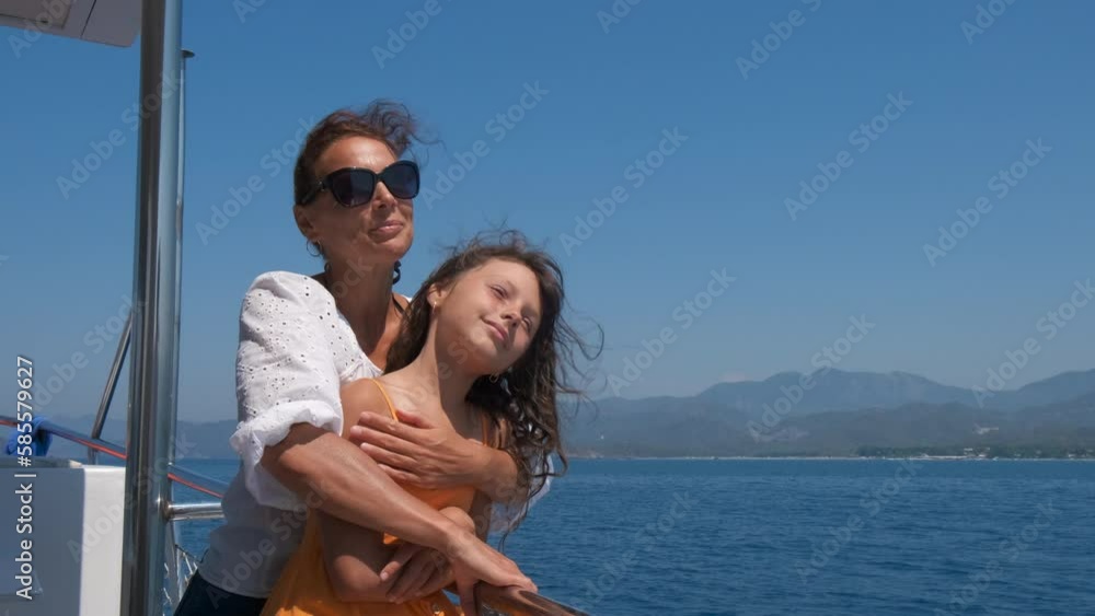 Mum and child relaxation on luxurious boat. A pretty mum in sunglasses hold her child and admire the sea scape from the sailing boat. Mum and child relaxation on luxurious boat. A pretty mum in sunglasses hold her child and admire the sea scape from the sailing boat.