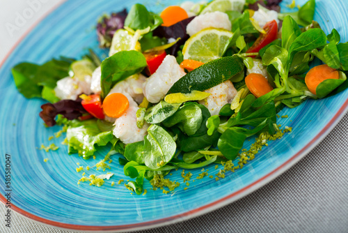 Tasty salad with cod and fresh greens. Recipe: marinate 200gr of chopped cod fillets in lime juice and black pepper. Serve with lettuce, carrots, sliced limes. Dress with oil and balsamic photo