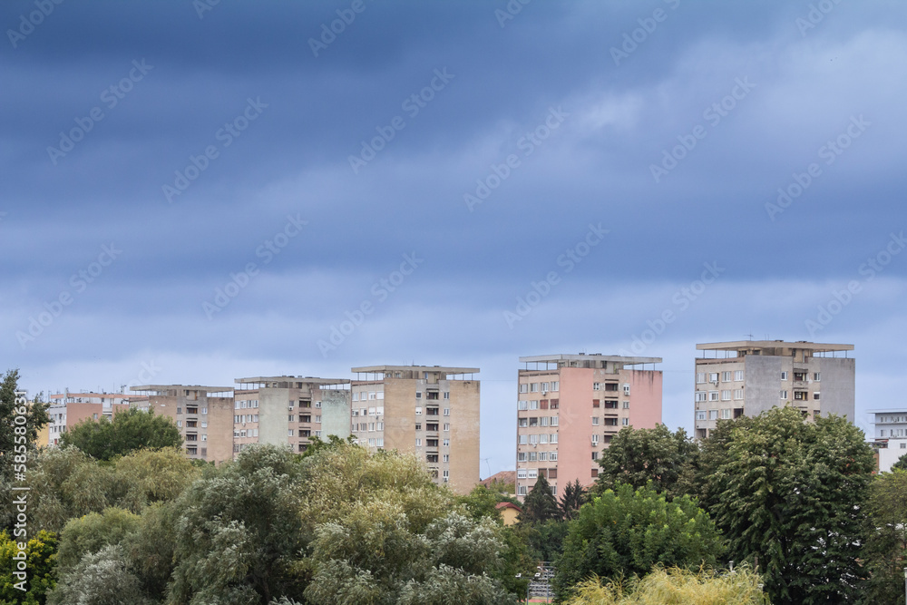 Selective blur on a High rise building from Arad, Romania, a traditional communist housing ensemble with a brutalist style, with a grey sky during a rainy afternoon.