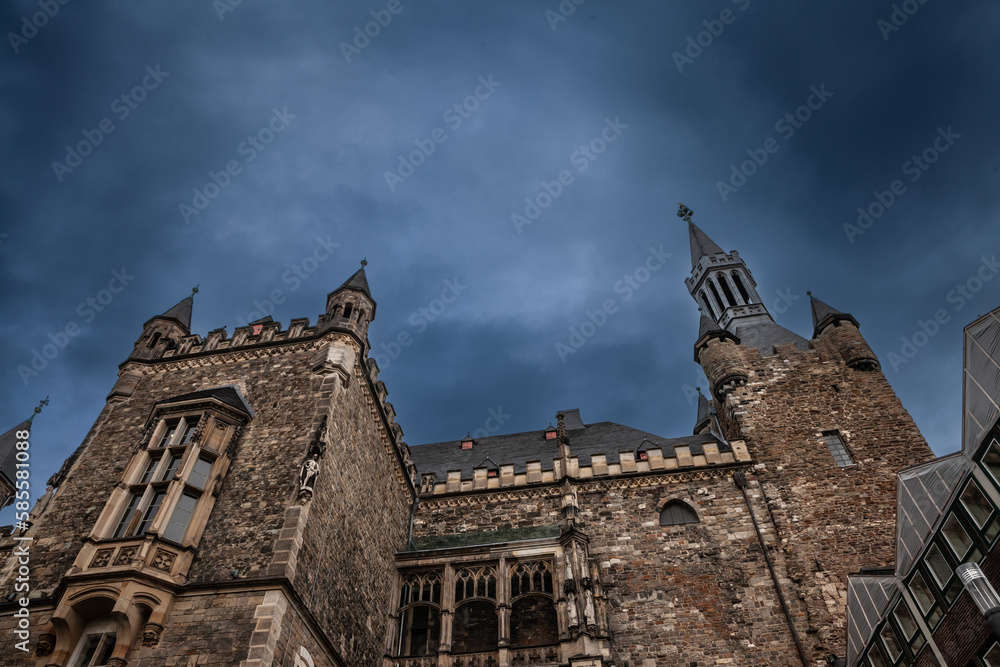 Main facade of the Aachener Rathaus, the city hall of Aachen, Germany during a rainy cloudy afternoon. It's a major medieval landmark of the city of Aachen.