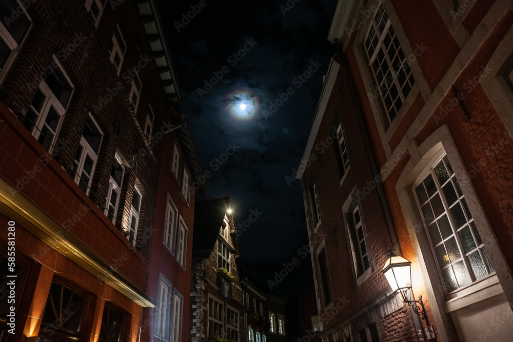 Selective blur on typical old medieval facades on a narrow street of Aachen, in the city center of the medieval part of the town, at night, lit by the moon and the moonlight. Selective blur on typical old medieval facades on a narrow street of Aachen, in the city center of the medieval part of the town, at night, lit by the moon and the moonlight.