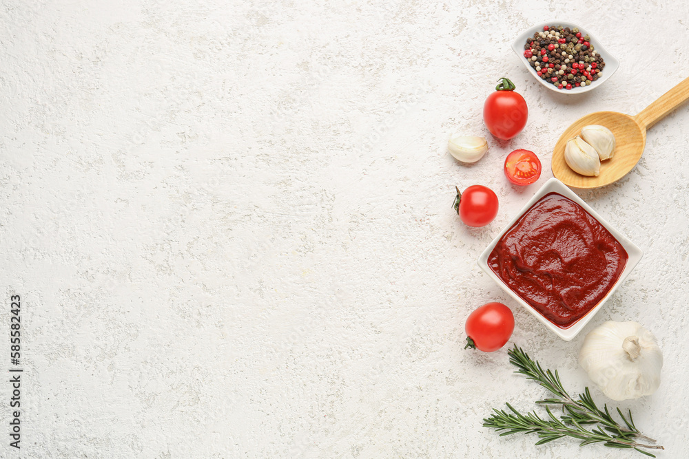 Composition with bowl of tasty tomato paste, garlic, peppercorn and rosemary on white grunge background Composition with bowl of tasty tomato paste, garlic, peppercorn and rosemary on white grunge background