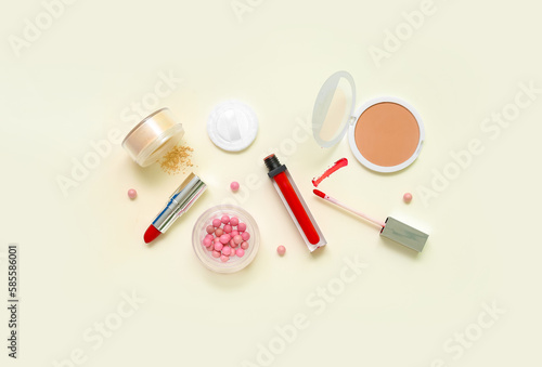 Lipsticks with makeup powder on beige background
