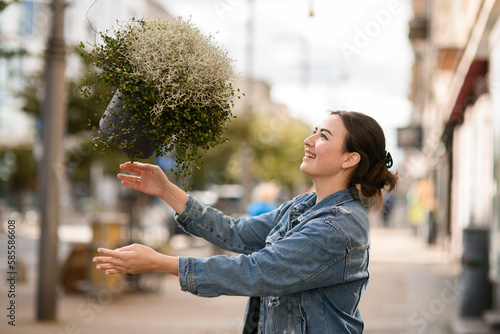 side view on woman and pot with leucophyta and green soleirolia plants in the air photo