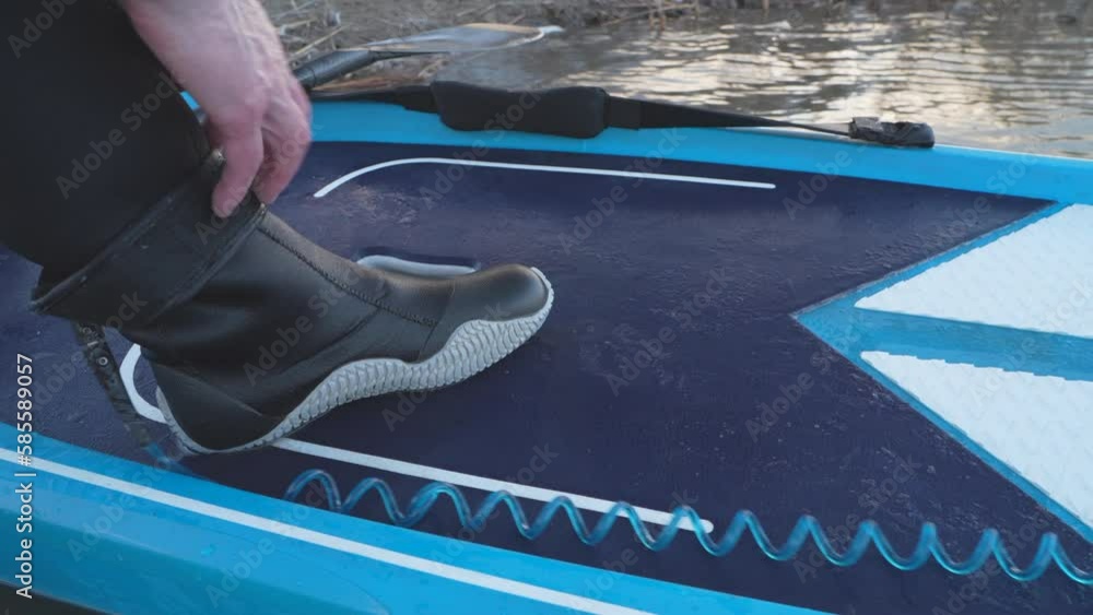 attaching a safety leash with velcro wrap to an ankle on a deck of