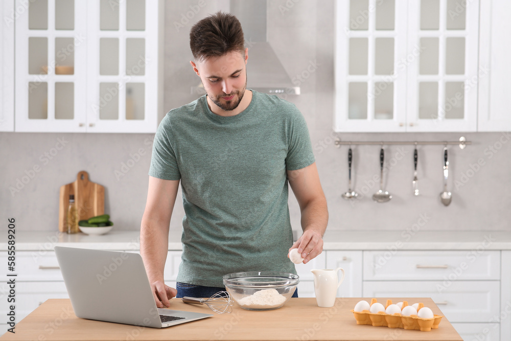 Man learning to cook with online video at table in kitchen. Time for hobby Man learning to cook with online video at table in kitchen. Time for hobby