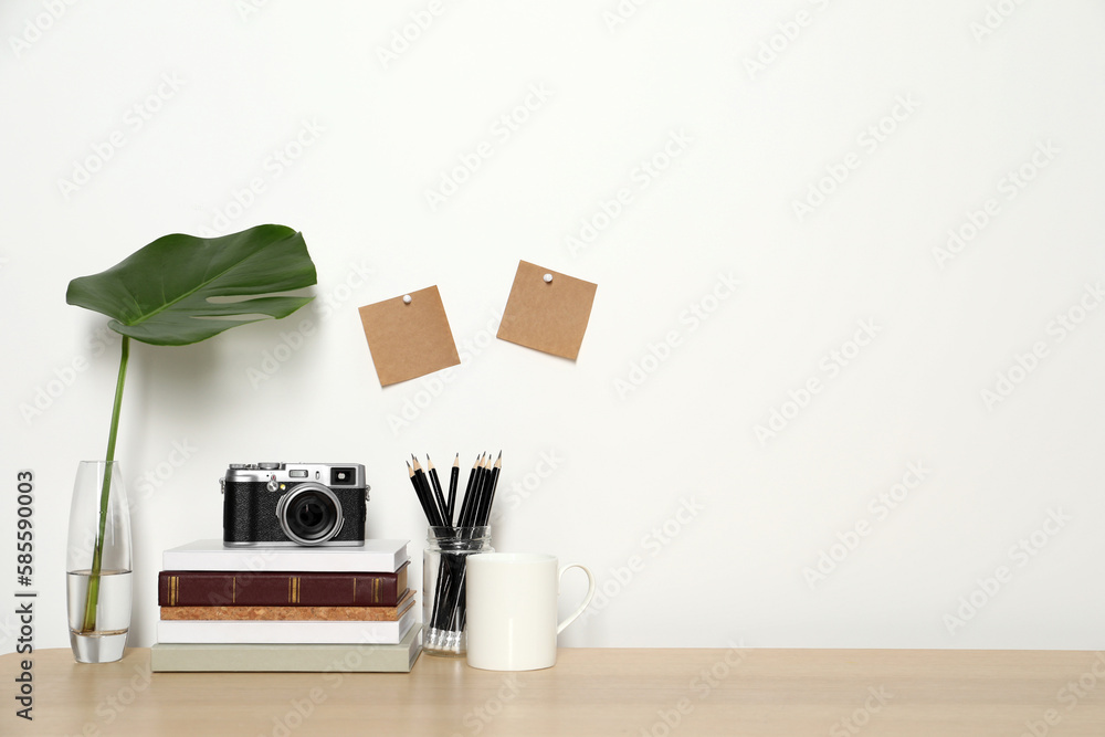 Comfortable workplace with wooden desk near white wall. Space for text Comfortable workplace with wooden desk near white wall. Space for text