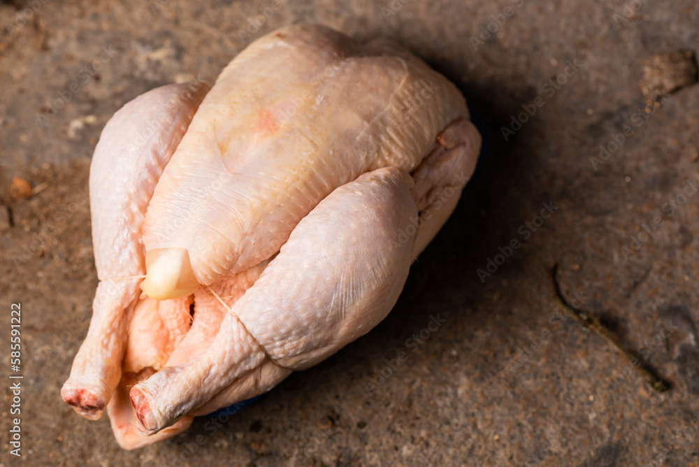 Raw shop chicken carcass on stone background. Whole chicken, preparation for cooking. Raw shop chicken carcass on stone background. Whole chicken, preparation for cooking.