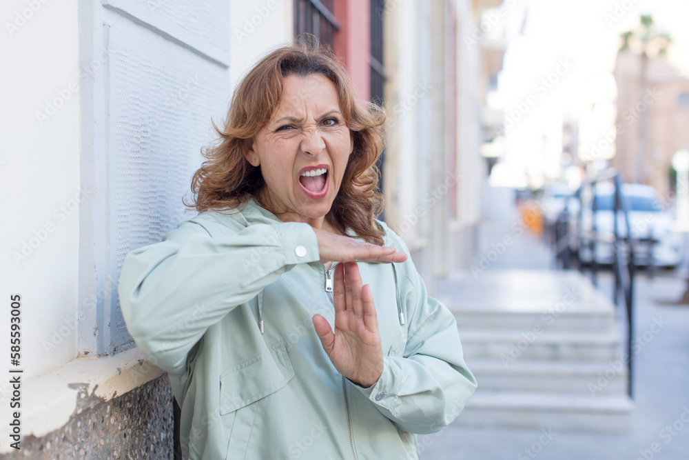 middle age woman looking serious, stern, angry and displeased, making time out sign middle age woman looking serious, stern, angry and displeased, making time out sign