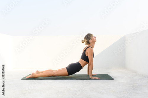 woman doing yoga outdoors on mat