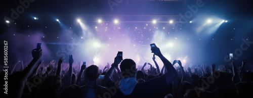 A crowd of people at a live event, concert or party holding smartphones. Large audience, crowd, or participants of a live event, in a arena type venue with bright lights above. Generative AI. photo
