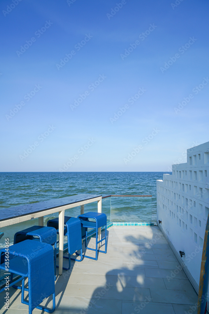 Fototapeta premium desk and bar stool near swimming pool with sea background