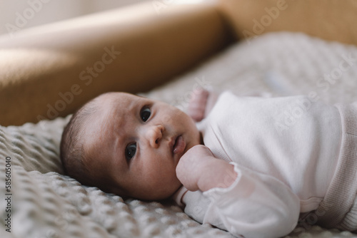 Portrait of a 1 month old baby. Cute newborn baby lying on a developing rug. Love baby. Newborn baby and mother. photo