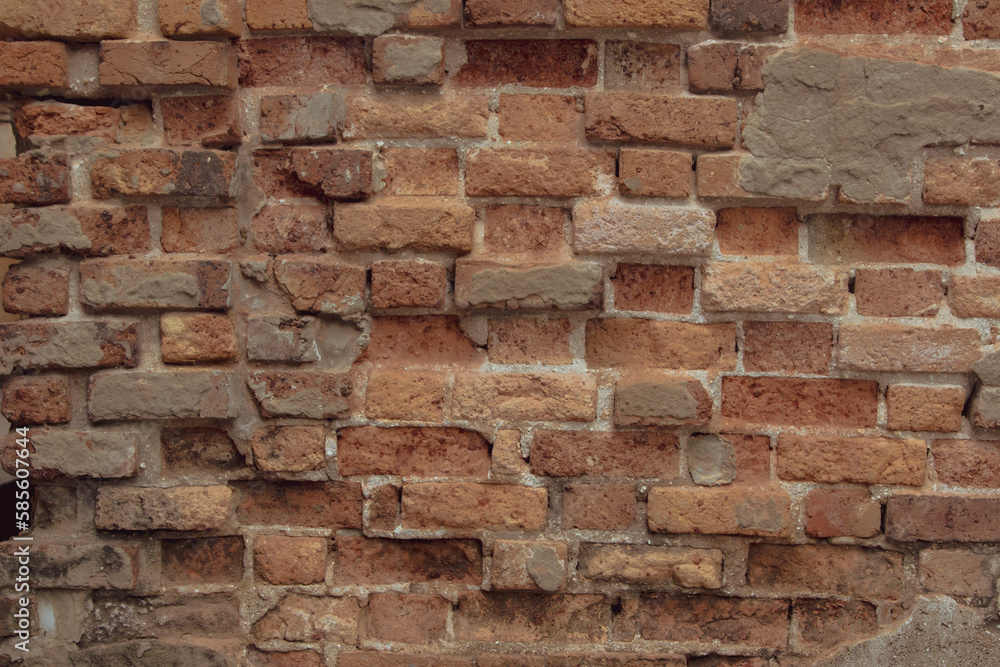 Ancient brick wall has traces of weathering damage over time. Orange and red brick wall texture background. Ancient brick wall has traces of weathering damage over time. Orange and red brick wall texture background.