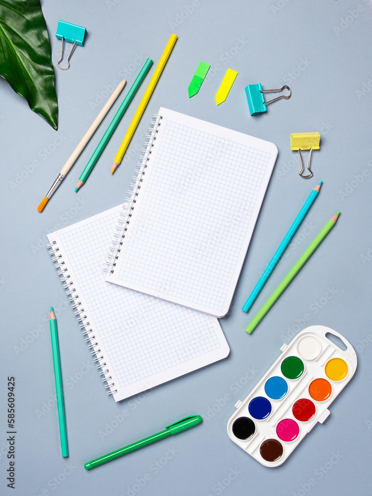 Flat lay office desk with a blank page of a notebook with a pen, pencils, watercolor and other stationery. Top view, flat lay. Flat lay office desk with a blank page of a notebook with a pen, pencils, watercolor and other stationery. Top view, flat lay.