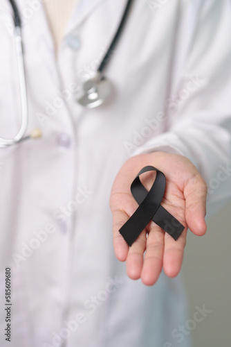 Melanoma and skin cancer, Vaccine injury awareness month and rest in peace concepts. doctor holding black Ribbon