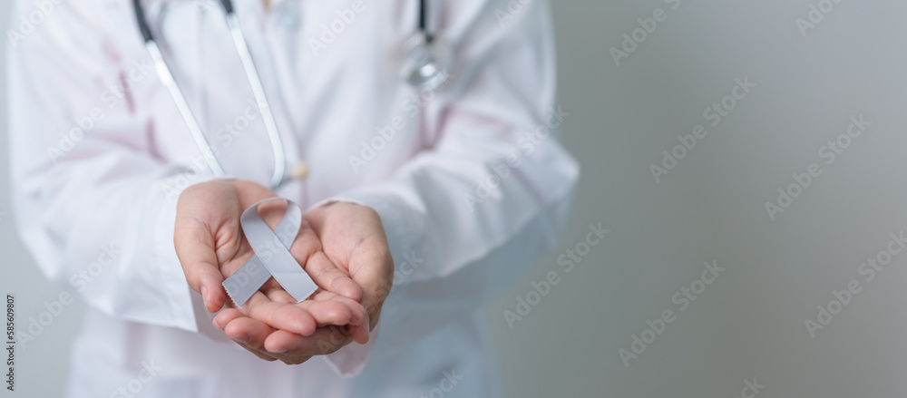 Brain Cancer Awareness May month, Doctor with grey color Ribbon for supporting life people. Healthcare and World cancer day concept Brain Cancer Awareness May month, Doctor with grey color Ribbon for supporting life people. Healthcare and World cancer day concept