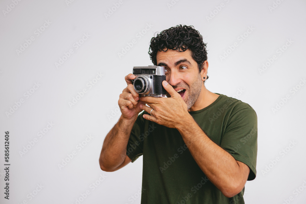 Middle-aged Latin man caught using an antique roll camera on a white background. Copy space. Middle-aged Latin man caught using an antique roll camera on a white background. Copy space.