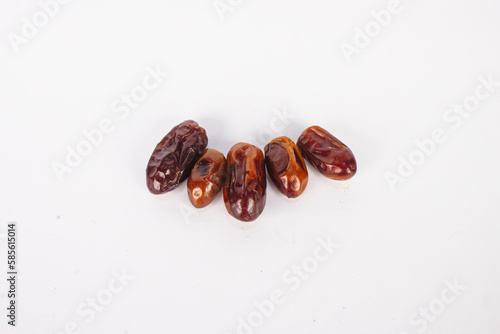 A group of brown dates are on a white background.