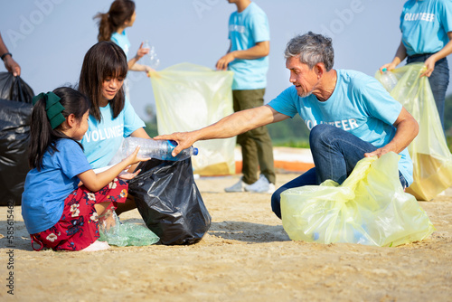 group of volunteers cleanup at the sand beach and adult help children collect and separate plastic bottle for recycle, concept of environmental conservation,  campaign, awareness, support