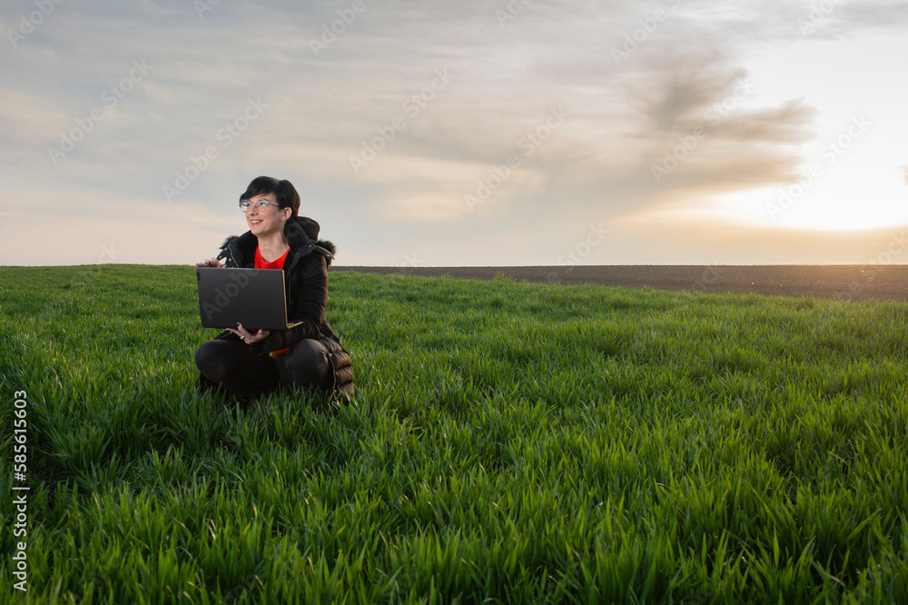 A woman agronomist examines planted young wheat A woman agronomist examines planted young wheat