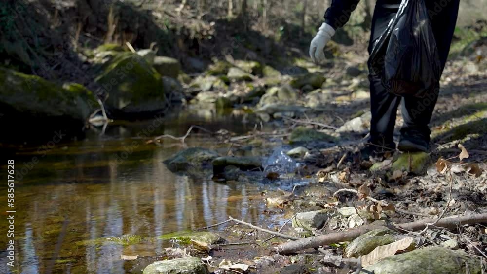 Man activist clean up plastic waste, littering rubbish in a river in a ...