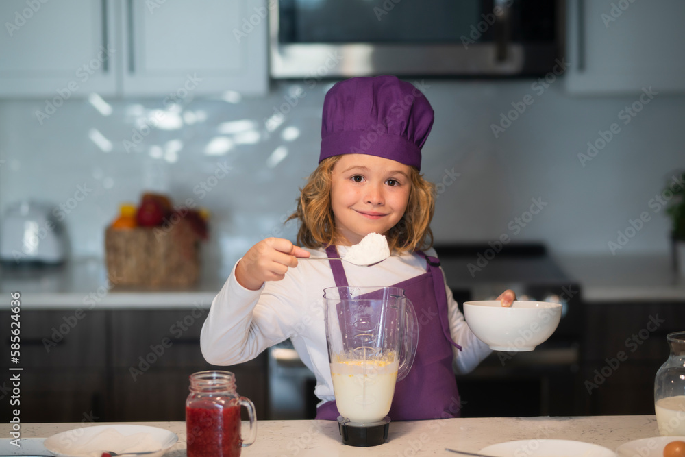 Child chef cooking meal. Child chef cook is learning how to make a cake in the home kitchen. Child chef cooking meal. Child chef cook is learning how to make a cake in the home kitchen.